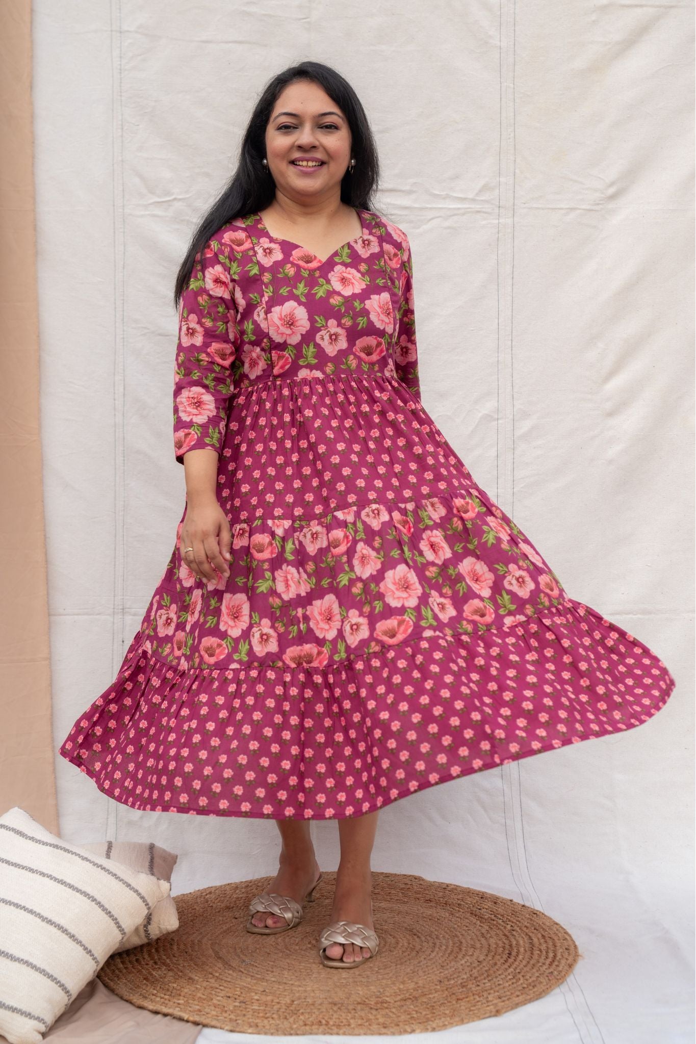 Woman wearing a pink floral dress standing on a white background