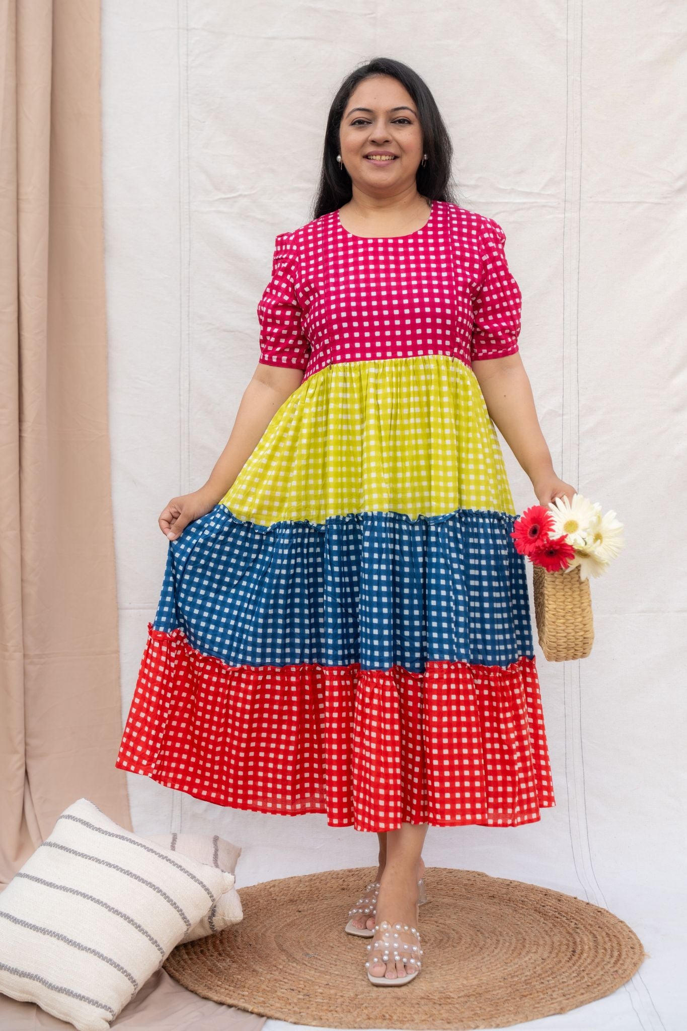 Woman wearing a colorful polka dot dress with a neutral background